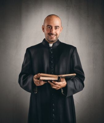 A married Catholic priest holding a Bible