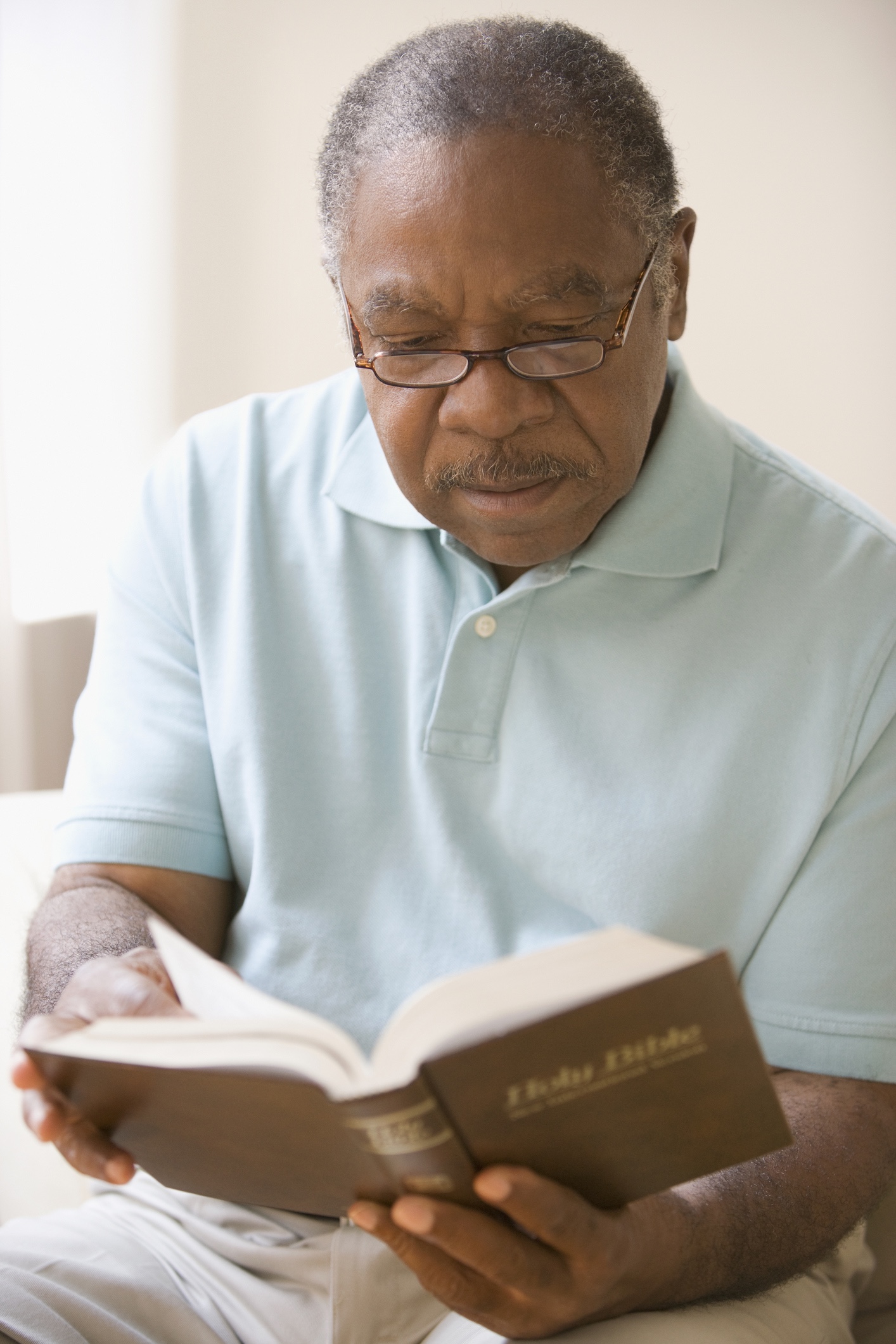 An older man reading a Bible. 