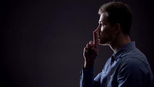 Person Holding Finger to Lips to Signify Silence