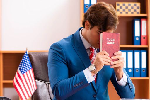 Politician holding Bible at desk