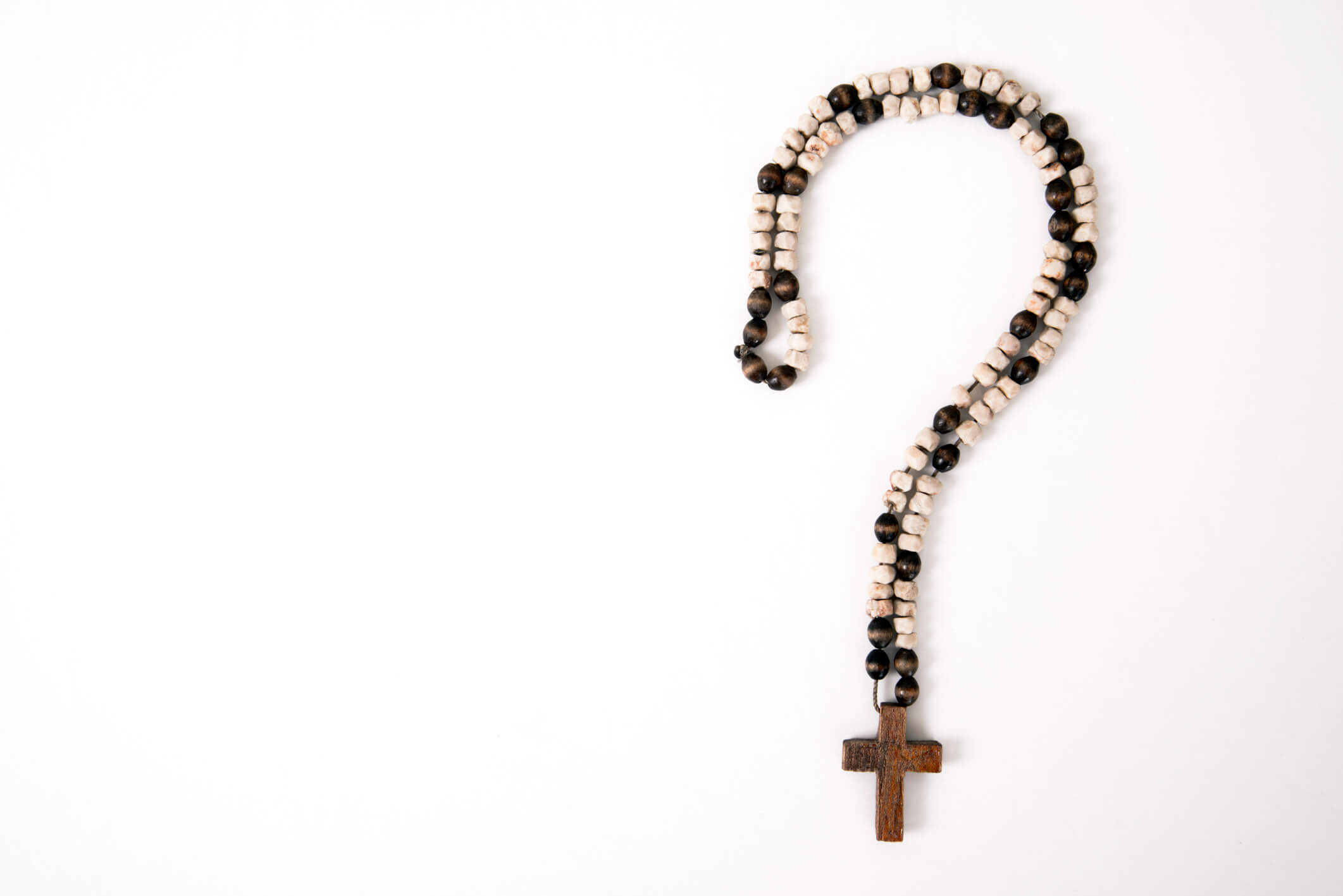 A cross necklace forming a question mark