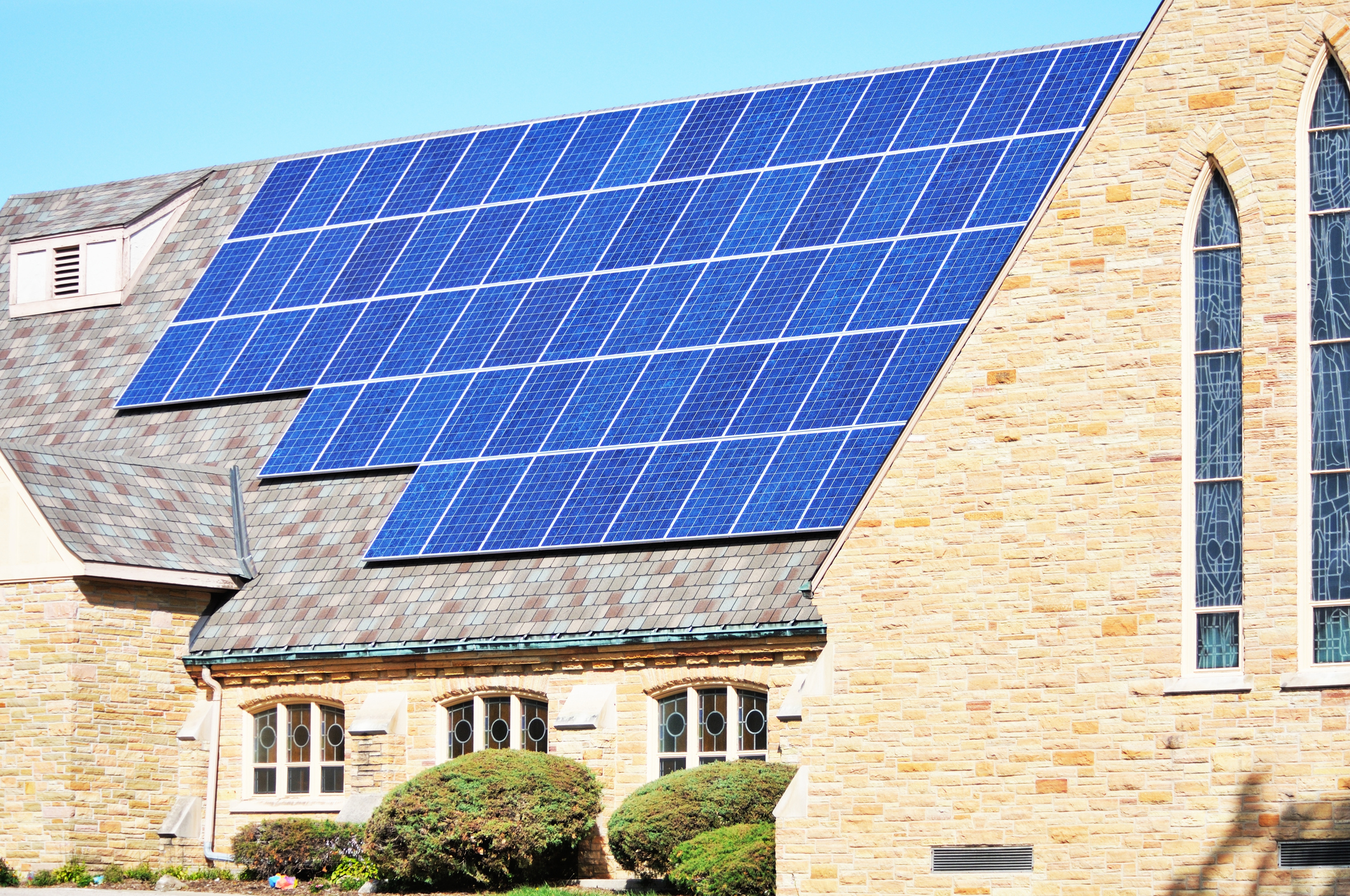 An Episcopal church with solar panels on the roof.