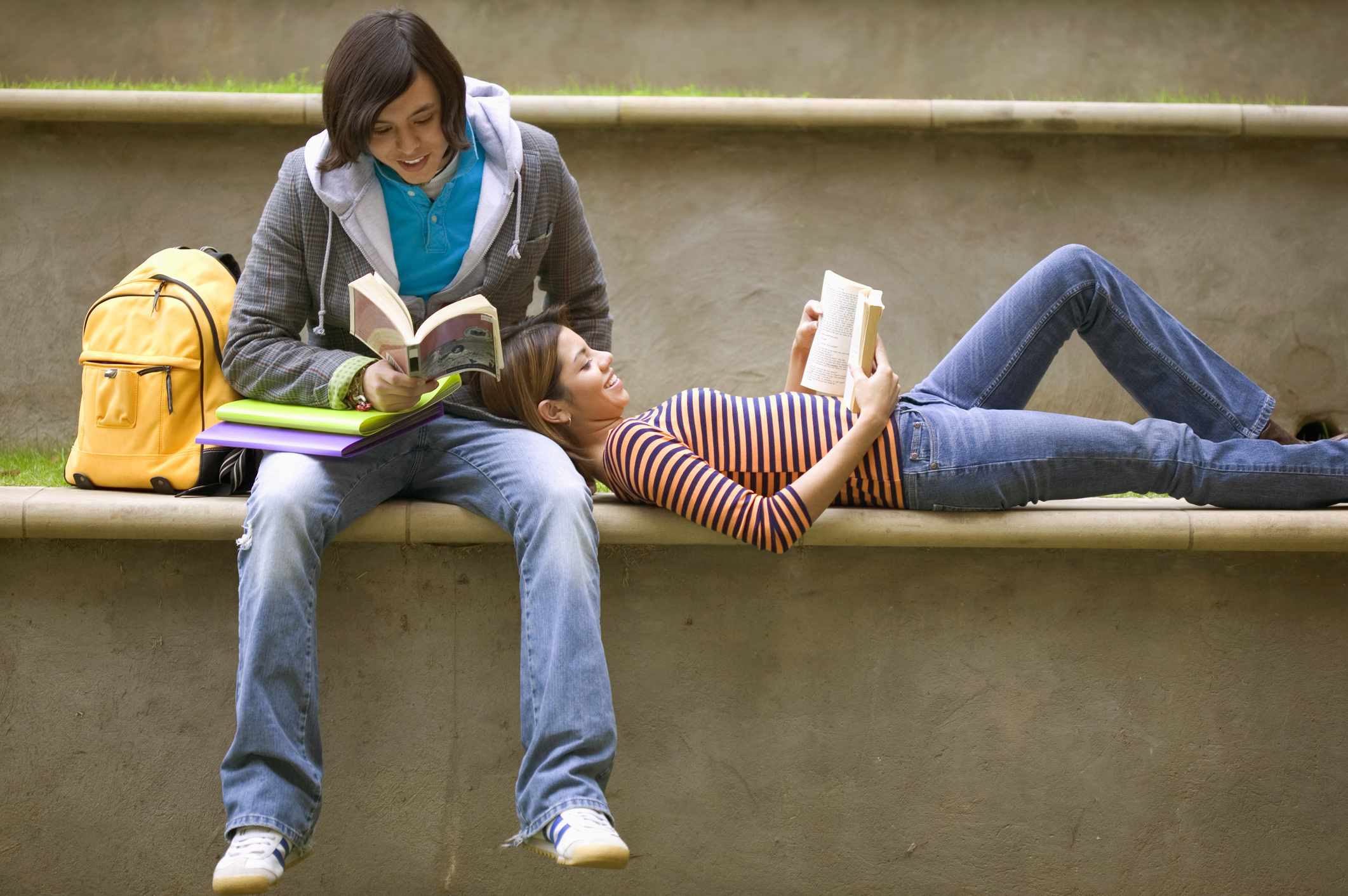 Teenagers relaxing and reading together