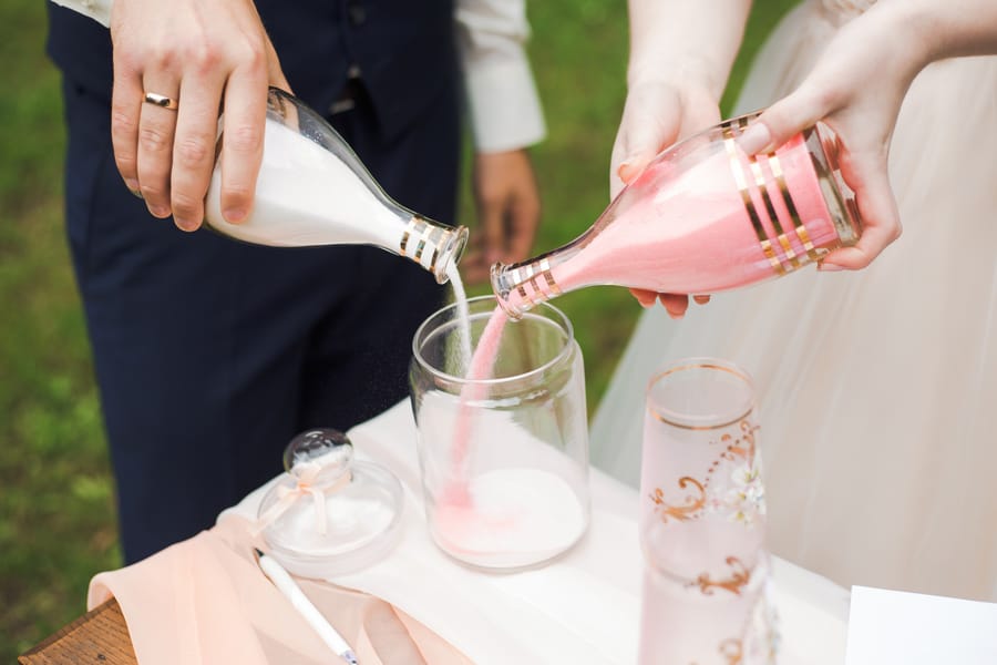 Bride and groom pouring salt to symbolize unity at wedding
