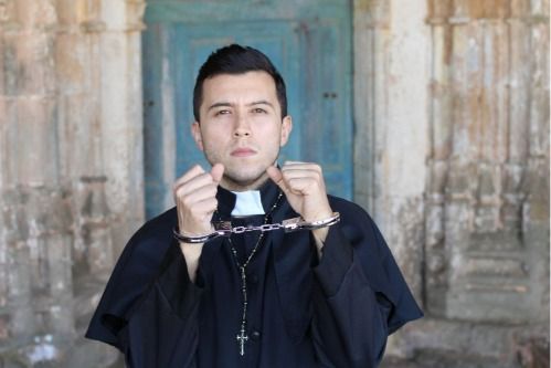 A religious leader in handcuffs