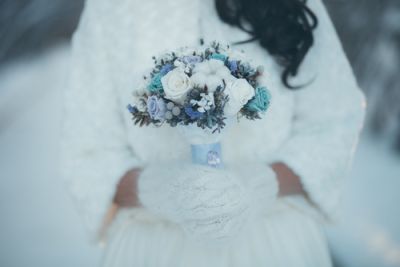 A bride wearing a warm dress and gloves for her winter wedding
