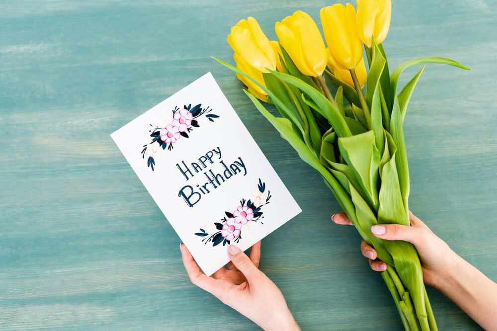 A birthday card next to tulips.
