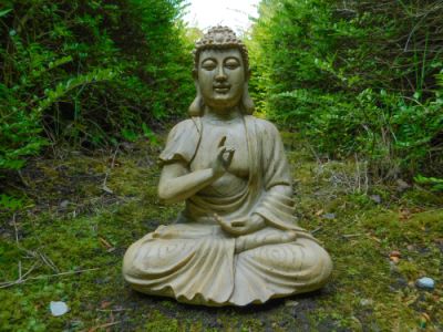A small Buddha statue in a garden