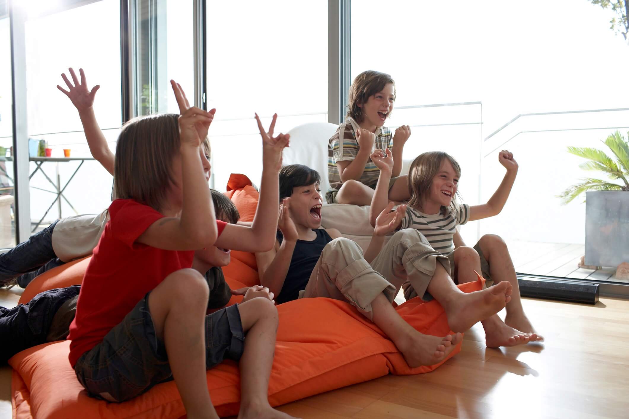 group of boys cheering in front of a television