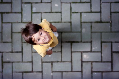 A child standing on the ground and looking up