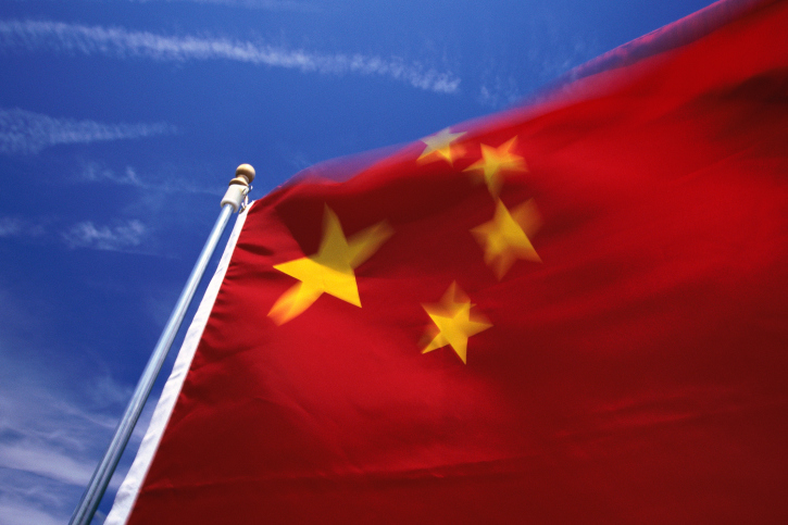 Chinese flag waving in front of a blue sky