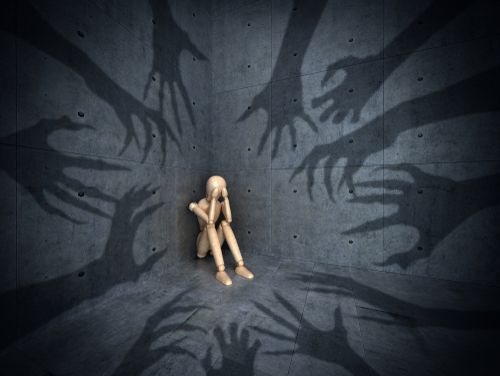 Twelve phobias reaching toward a wooden figure