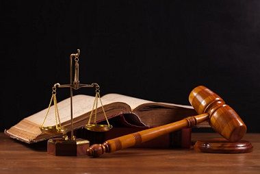 A gavel with scale and book on table