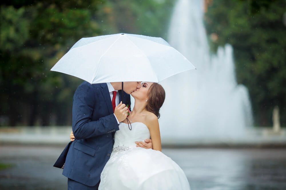wedding couple kissing in the rain