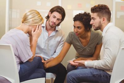 A group supporting their friend after learning how to perform an exorcism.