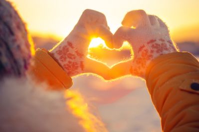 A person making the shape of a heart with their hands