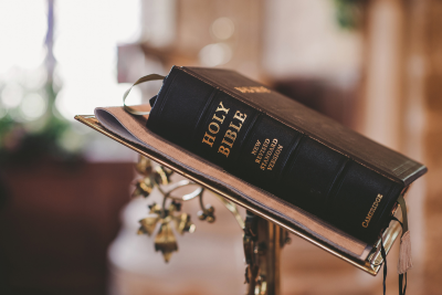 Holy Bible resting on a lectern inside a church.