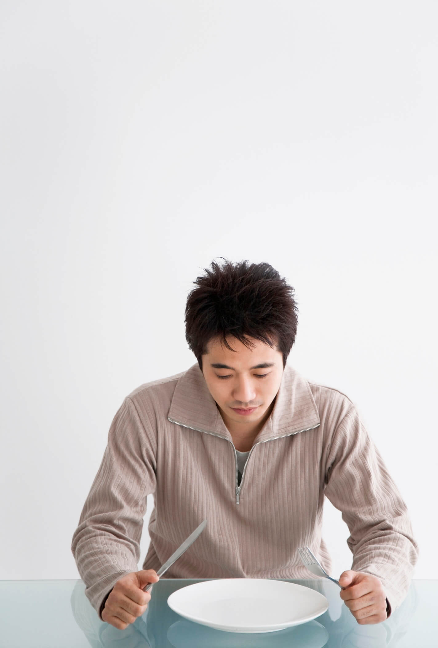 A man fasting while sitting at a table.