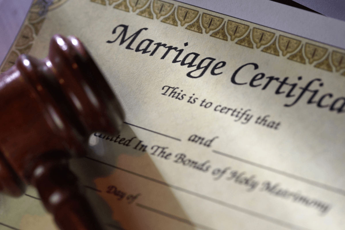 Close-up of a marriage certificate with a wooden gavel resting on it.
