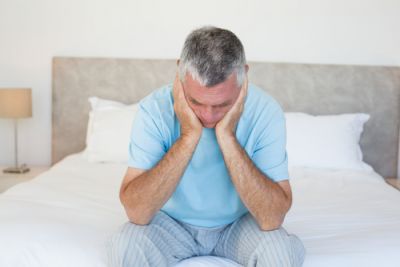 Lonely Man Sitting on Bed