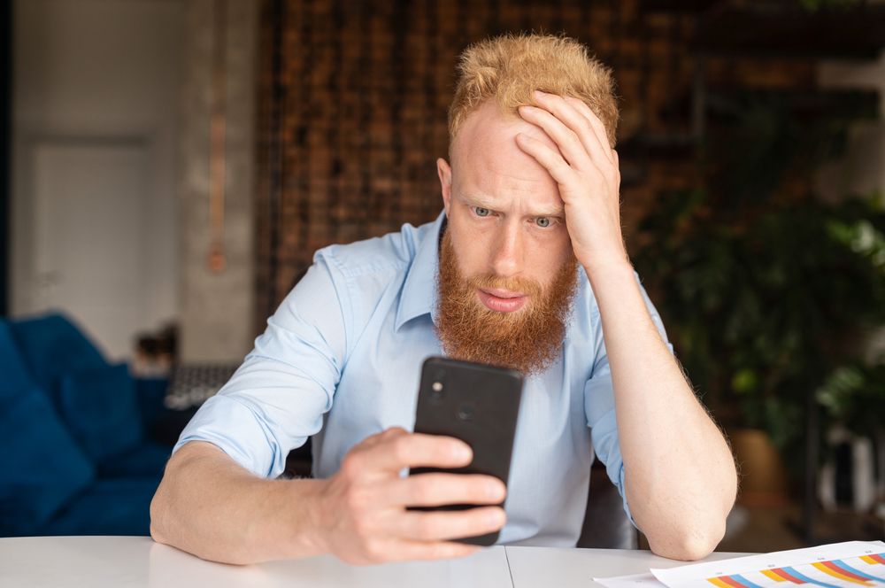 Man looking frustrated on his phone