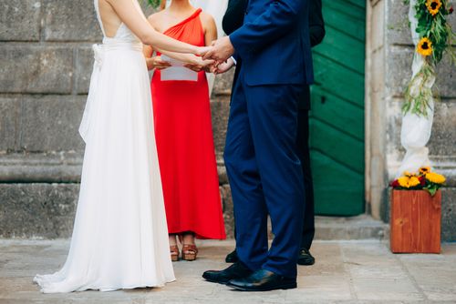 Minister in a Red Dress Marrying a Couple From a Script