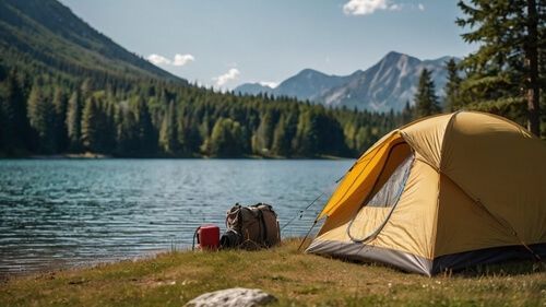 A tent set up outdoors in a pine forest in the mountains.