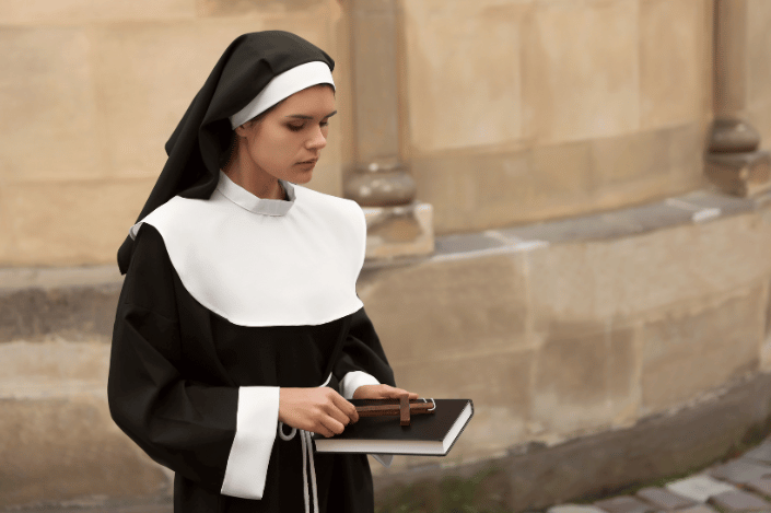 A young nun holding a cross and bible.