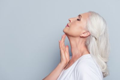 An aging woman touching her chin