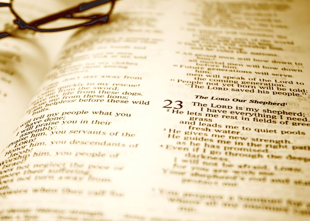 An open bible with glasses resting on them.