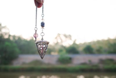 A divination pendulum held in the air.