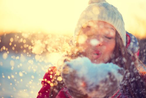 Person Blowing a Handful of Snow in Winter