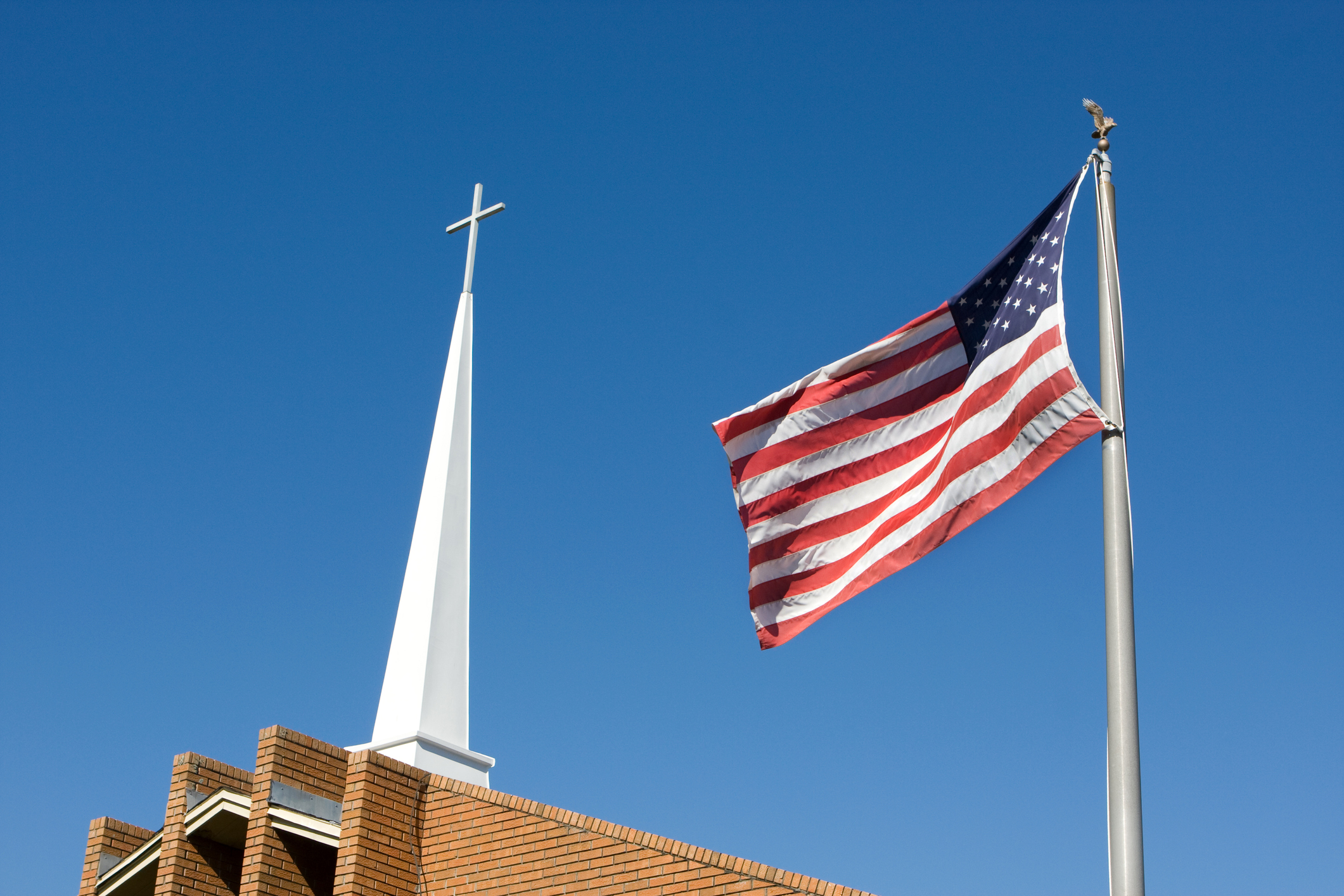 An American flag flying next to a church