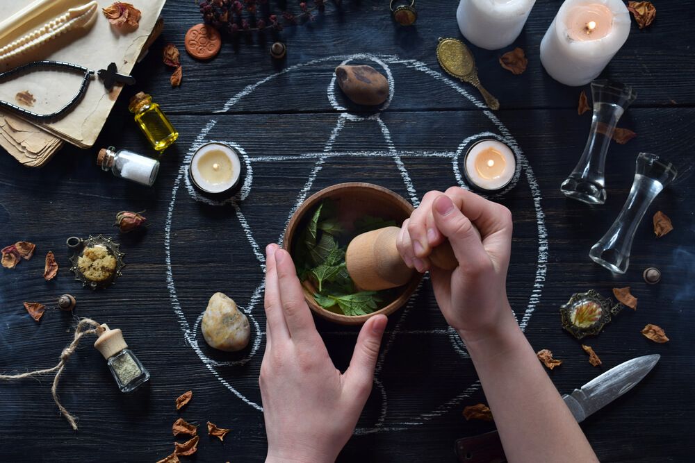 Hands making a potion on a pentagram.
