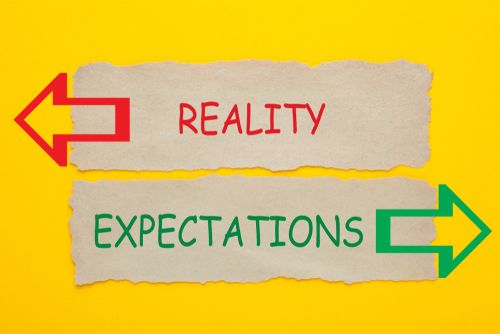 a sign directing expectations and reality