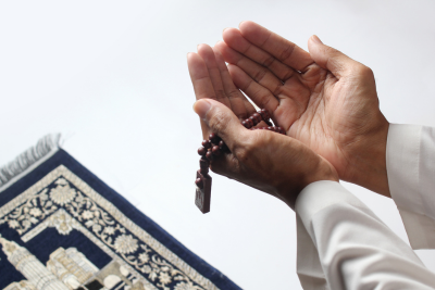 Muslim worshipper praying with tasbih beads