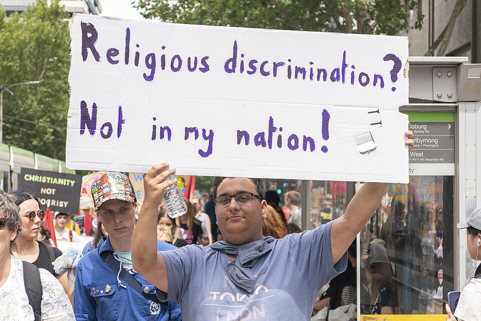 Person holding a sign reading