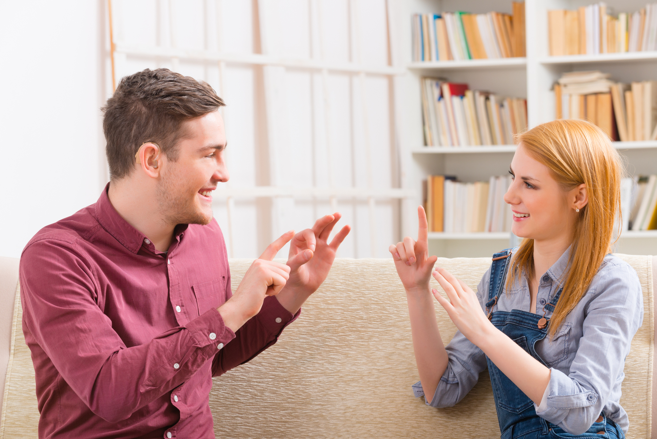 A man and woman signing to each other