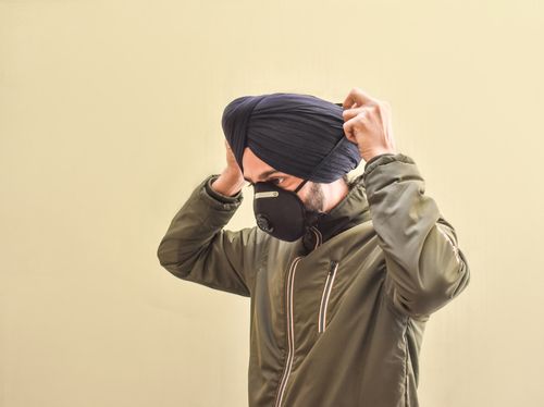 Sikh Man Putting On a Mask