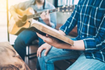 A man singing a hymn with Bible in hand