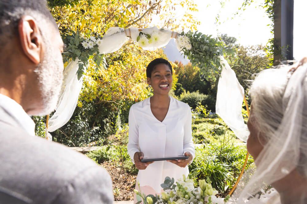 A smiling officiant performing a wedding.