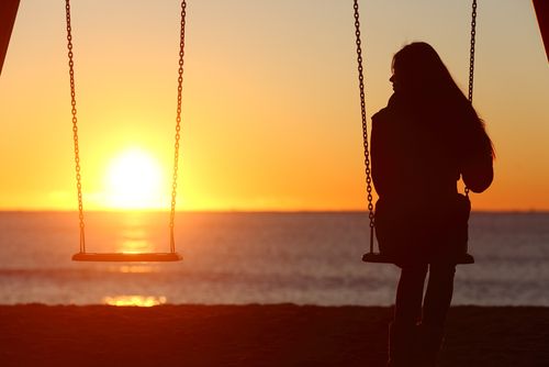 Solitary Woman Sitting on a Swingset