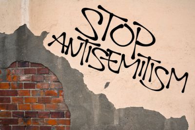 Faux graffiti reading Stop Anti-Semitism on a brick wall