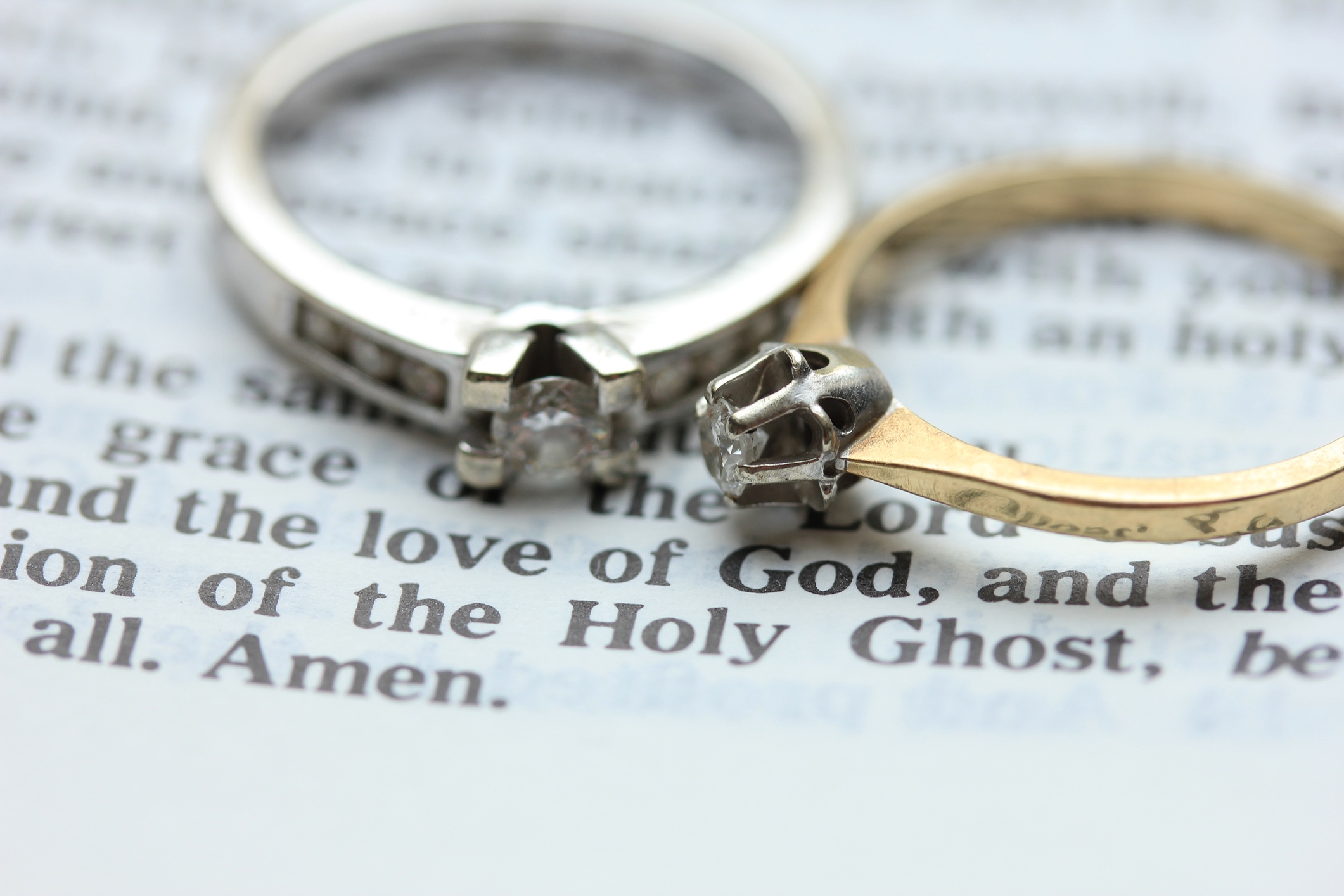 A pair of diamond rings on top of a Bible page