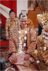 Groom kneeling during a traditional Indonesian wedding ceremony