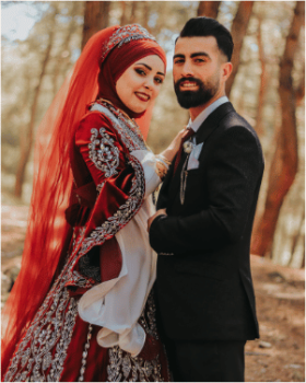 Bride and groom posing outdoors in traditional red wedding attire