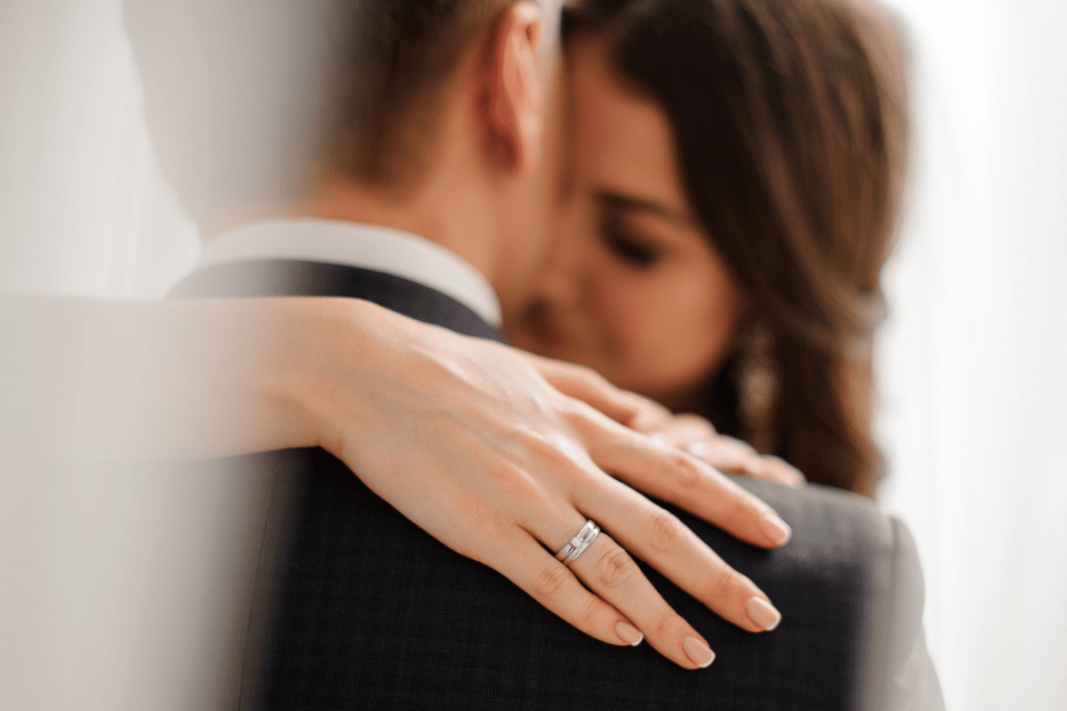 Bride embracing her partner with a wedding ring visible on her hand