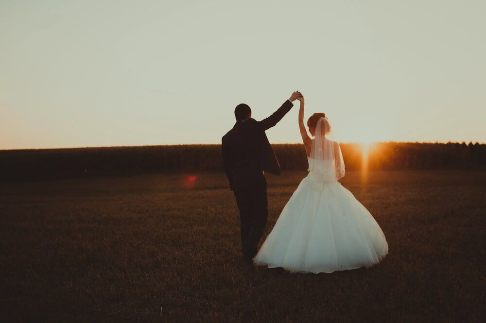 Wedding couple hugging beneath trees