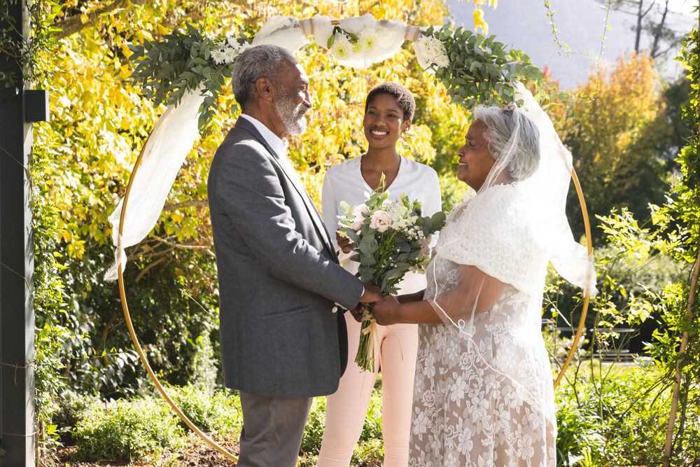 a female wedding officiant performing wedding for older couple