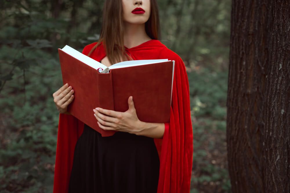 A woman in a red cloak in the forest.